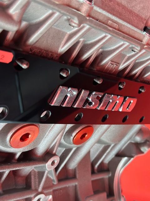 A close up of a nissan logo on a car engine