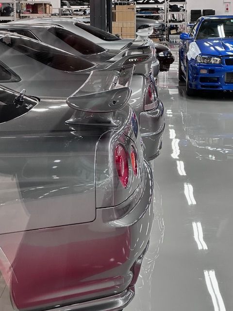 A row of cars are parked in a garage.