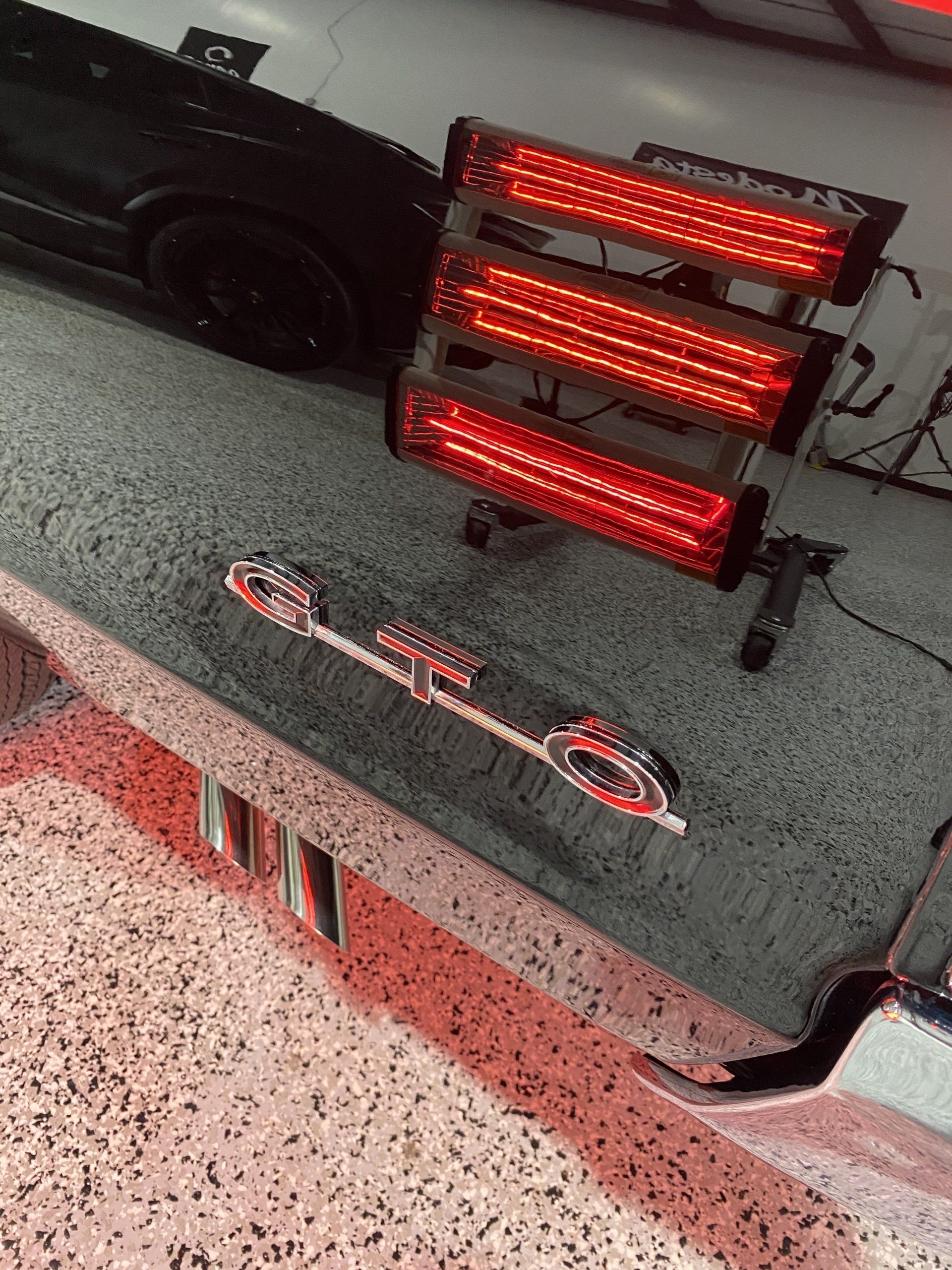 A car is sitting in a garage next to a red light.