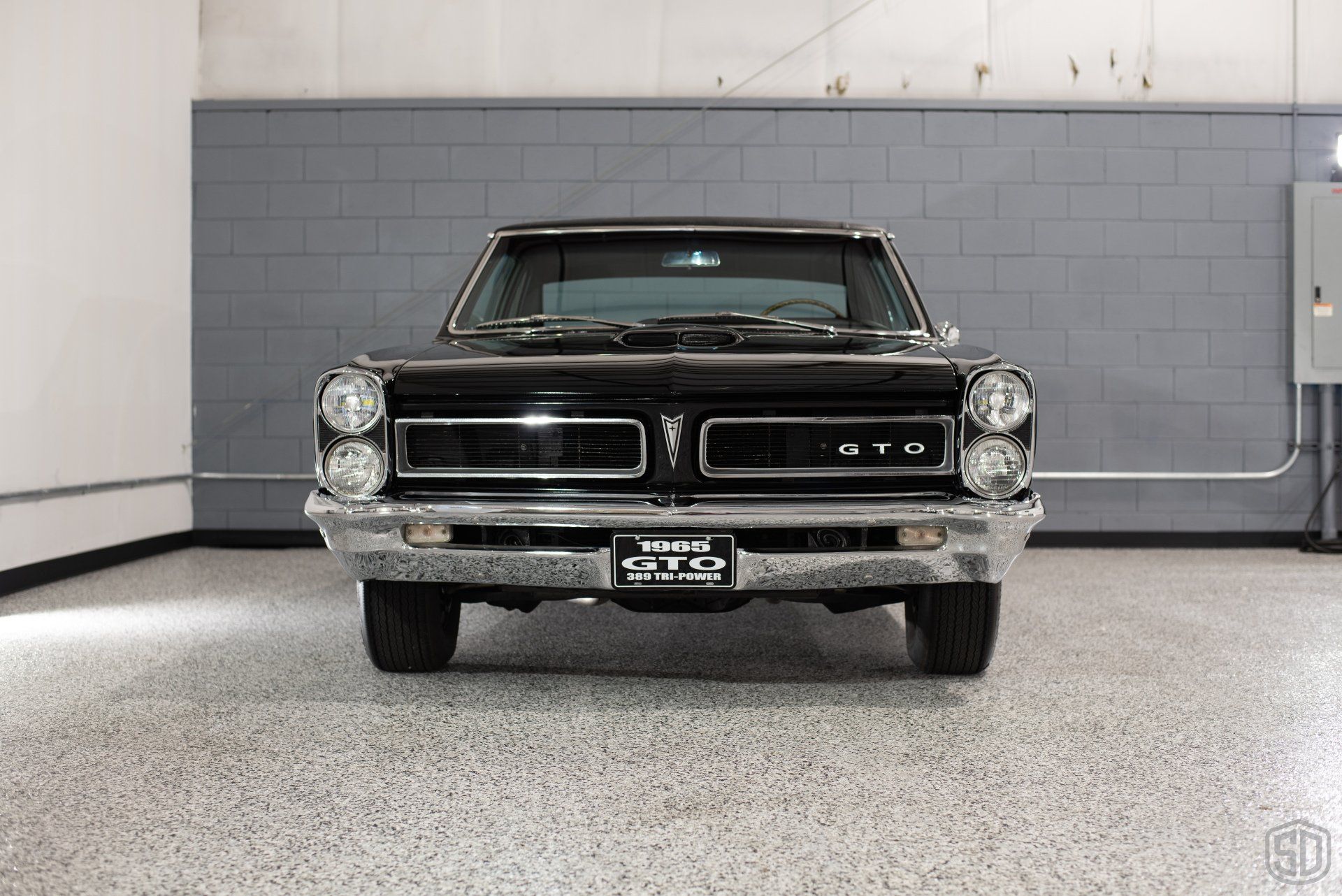 A black car is parked in a garage.
