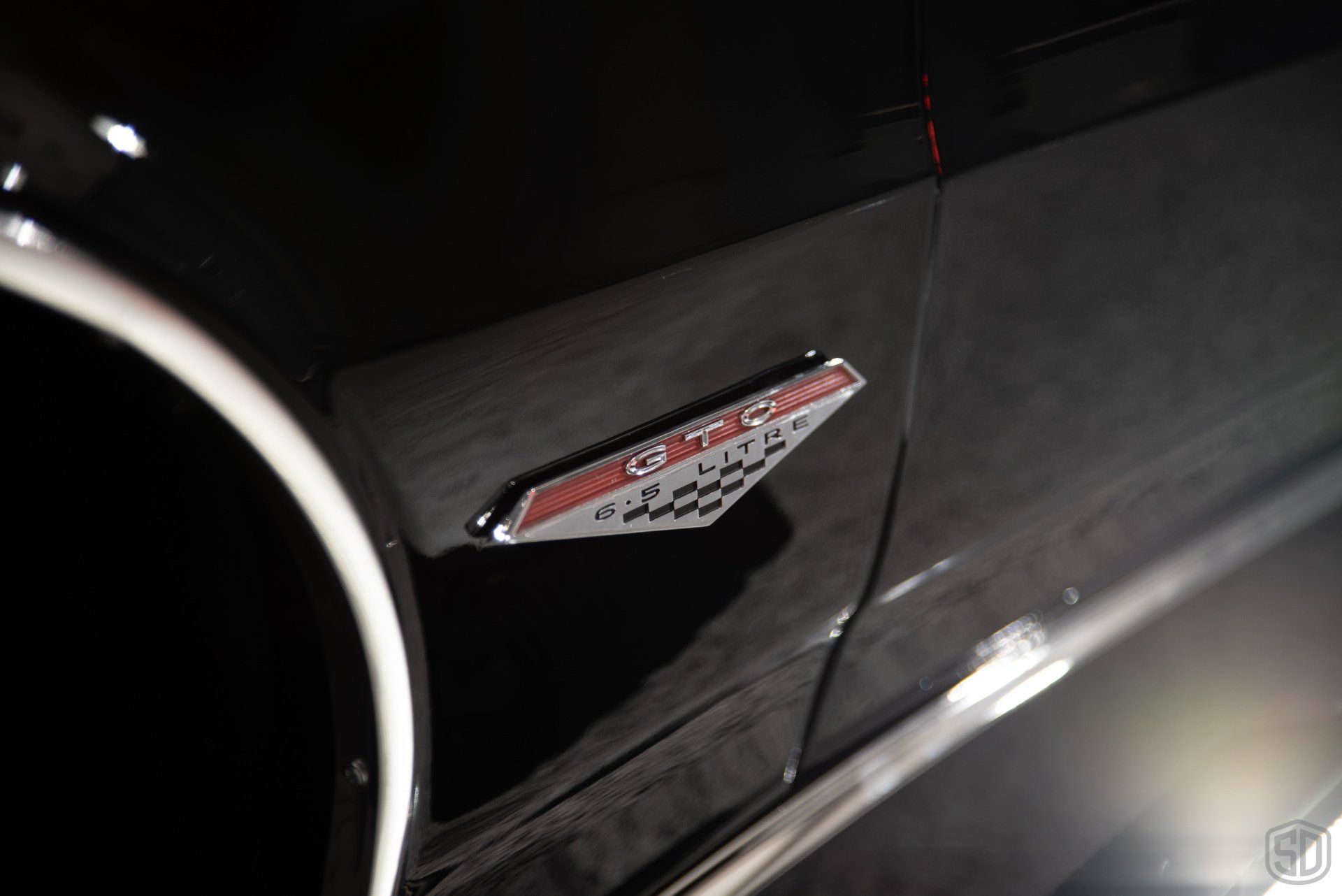 A close up of a black car with a badge on the side