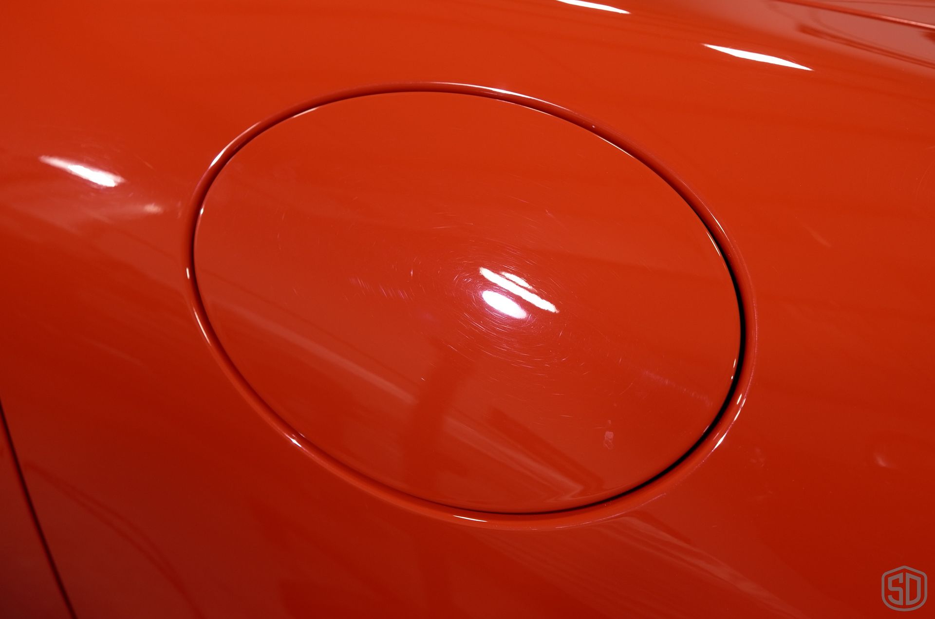 A close up of an orange car 's gas cap