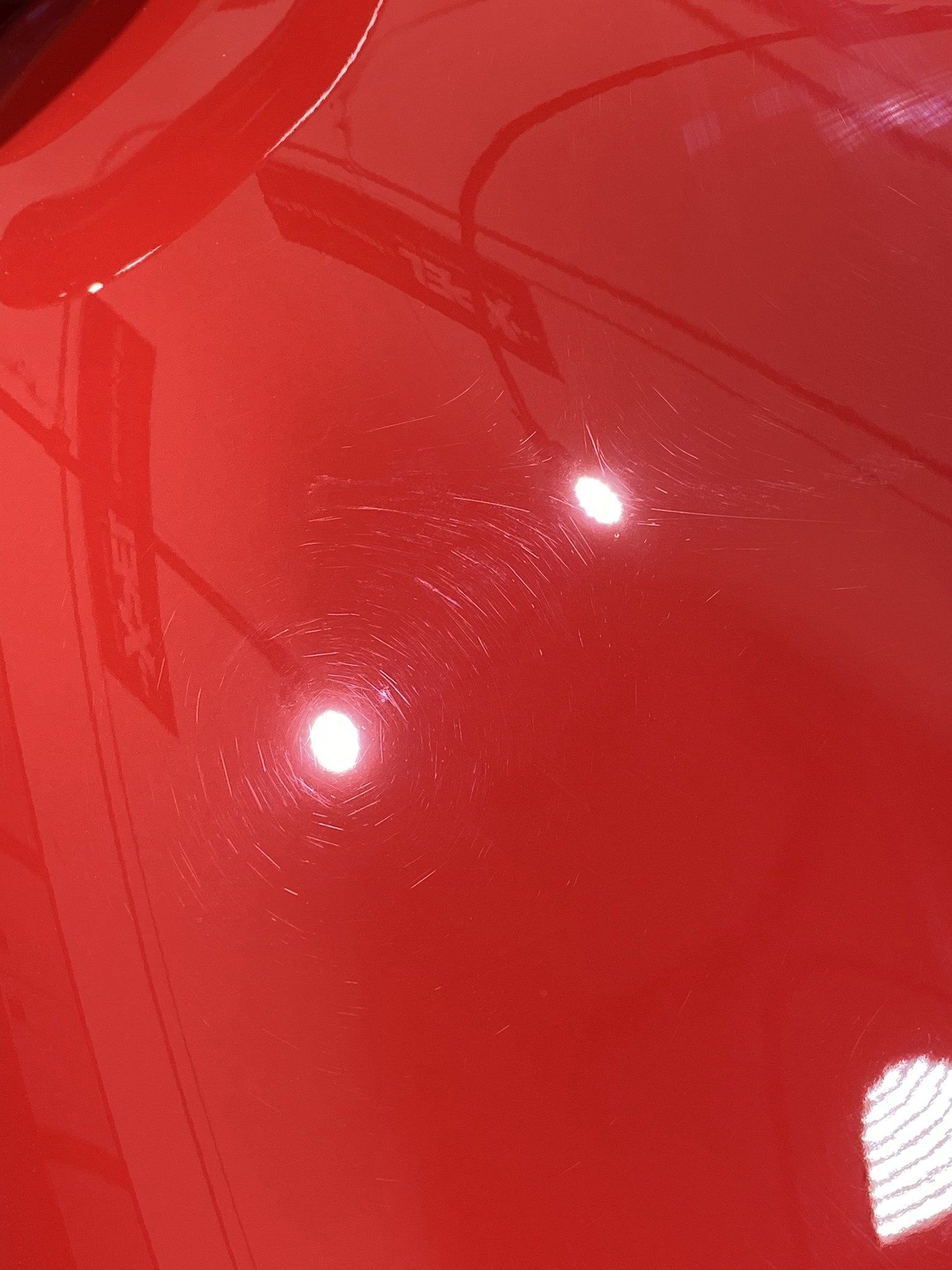 A close up of the hood of a red car.