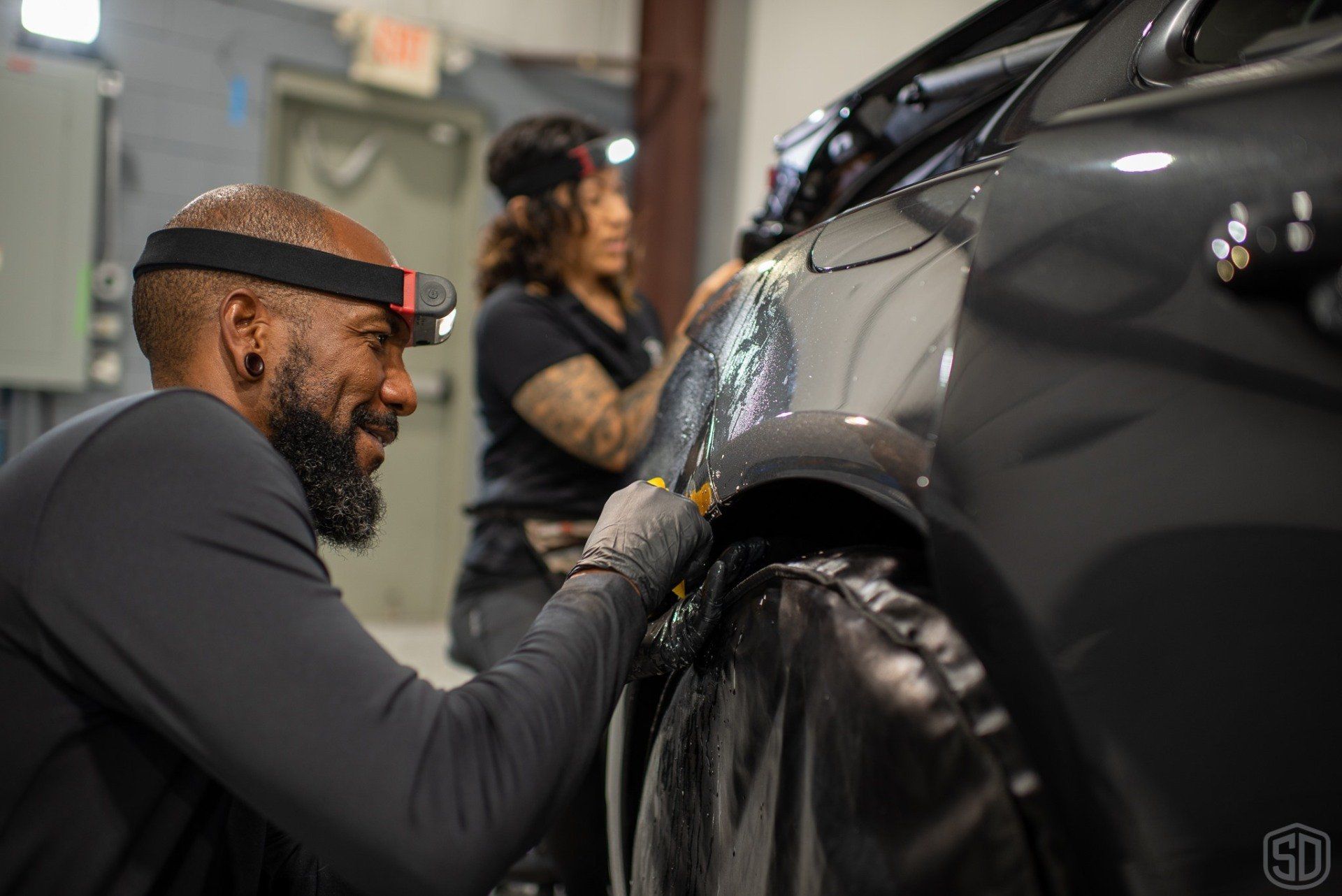 Karim and Kim installing Paint Protection Film on a porsche panamera