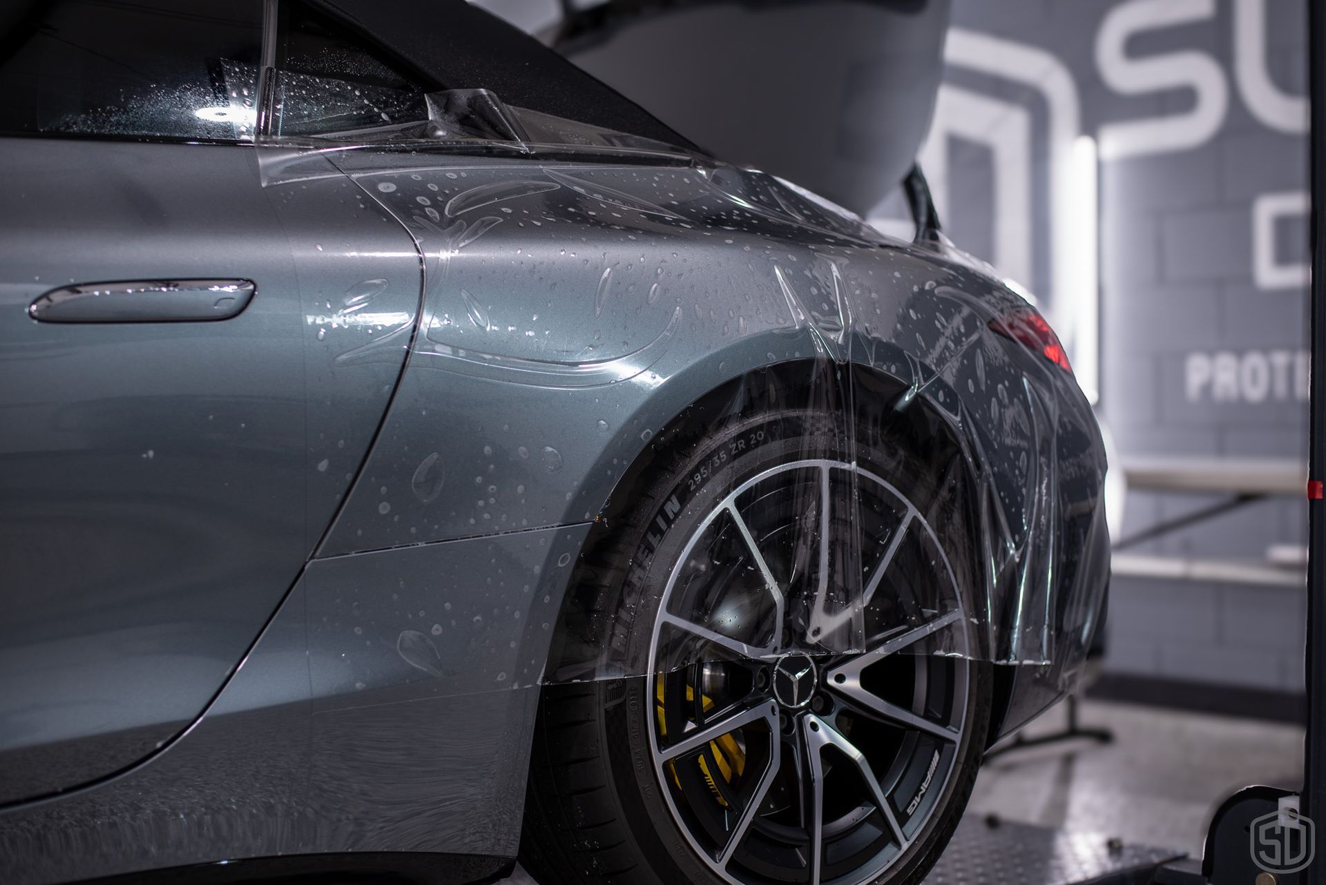 A close up of a car with a protective film on it.