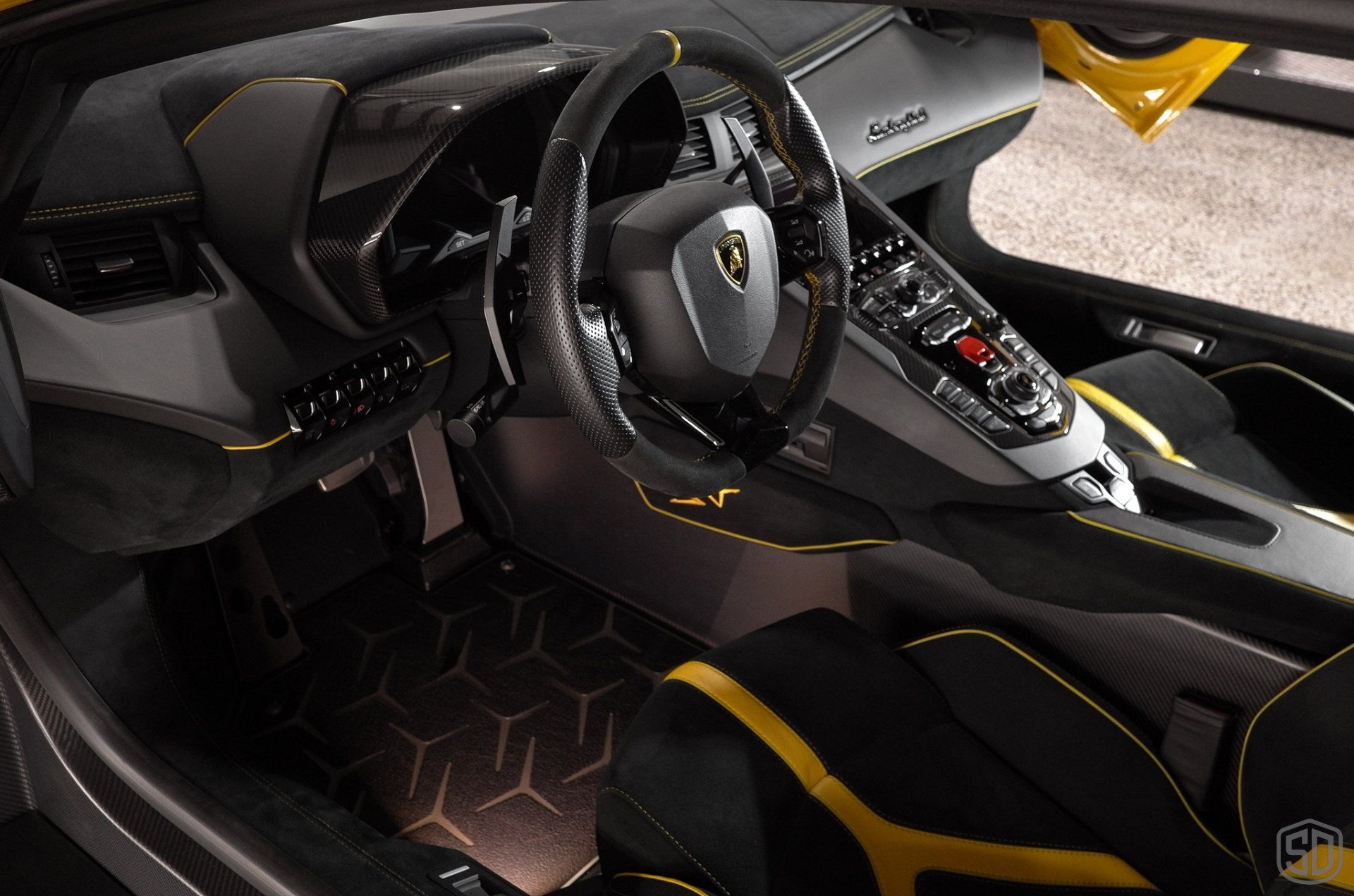 The interior of a black and yellow lamborghini aventador