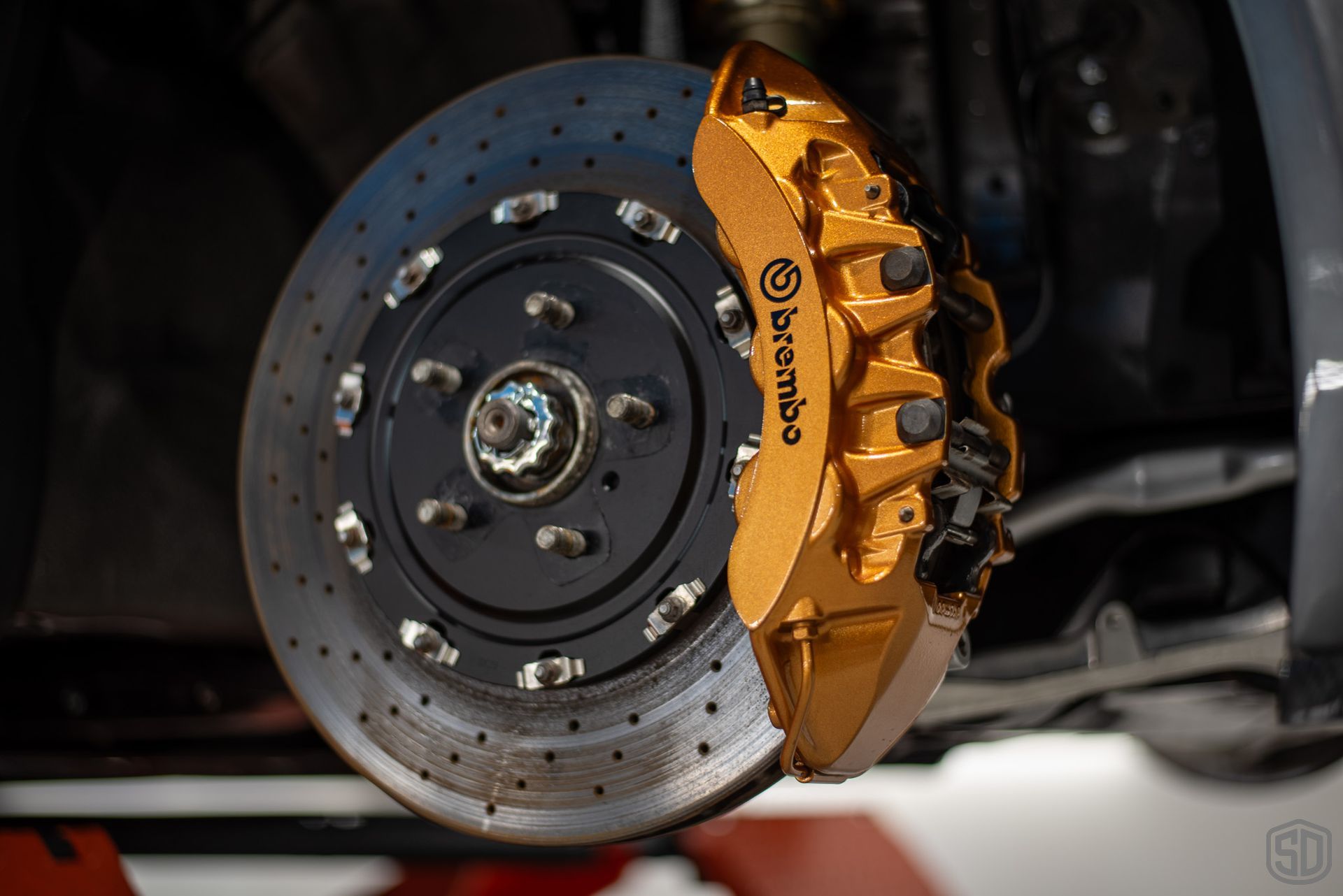 A close up of a brembo brake caliper on a car.