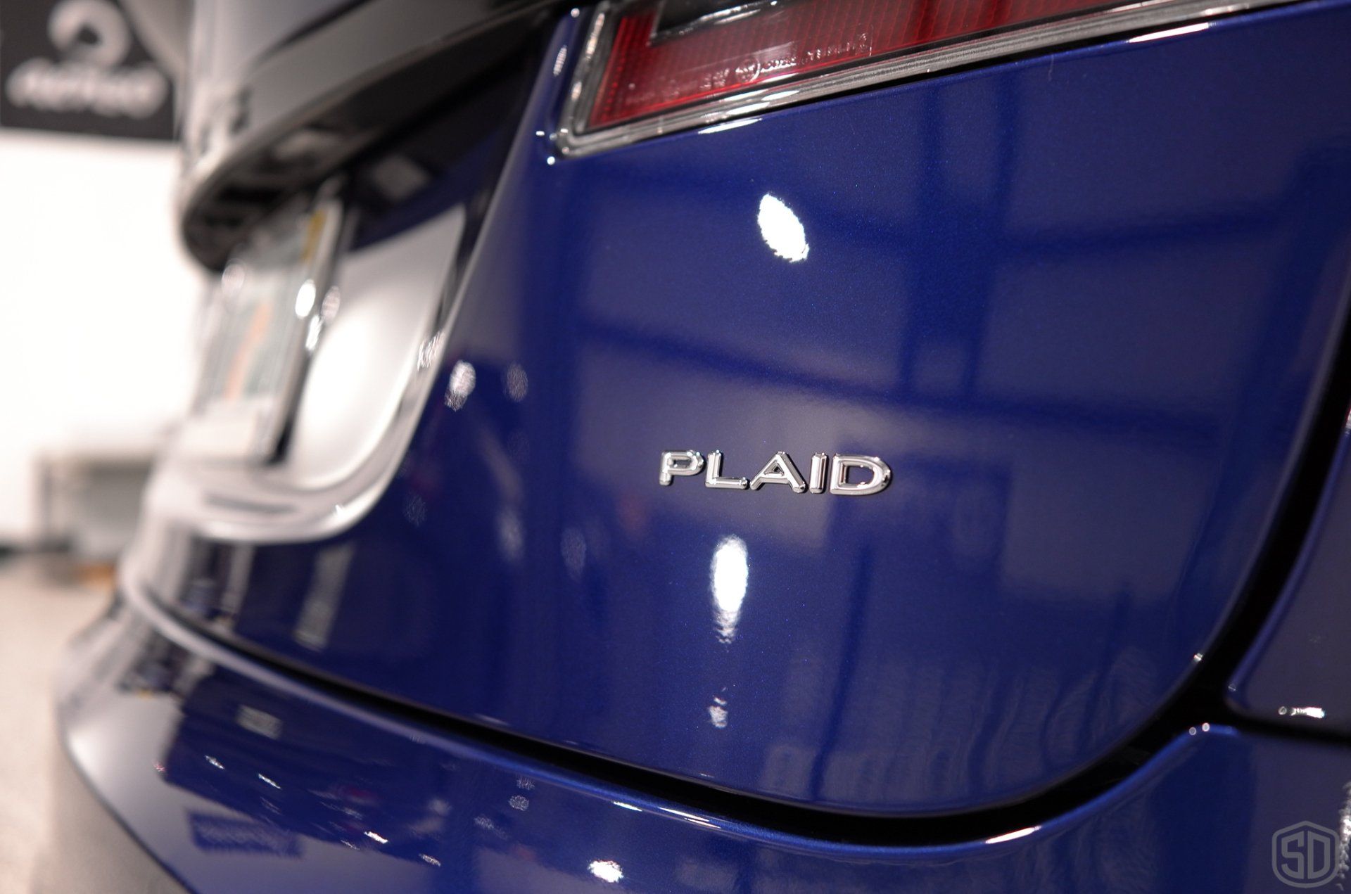 A blue plaid car is parked in a showroom