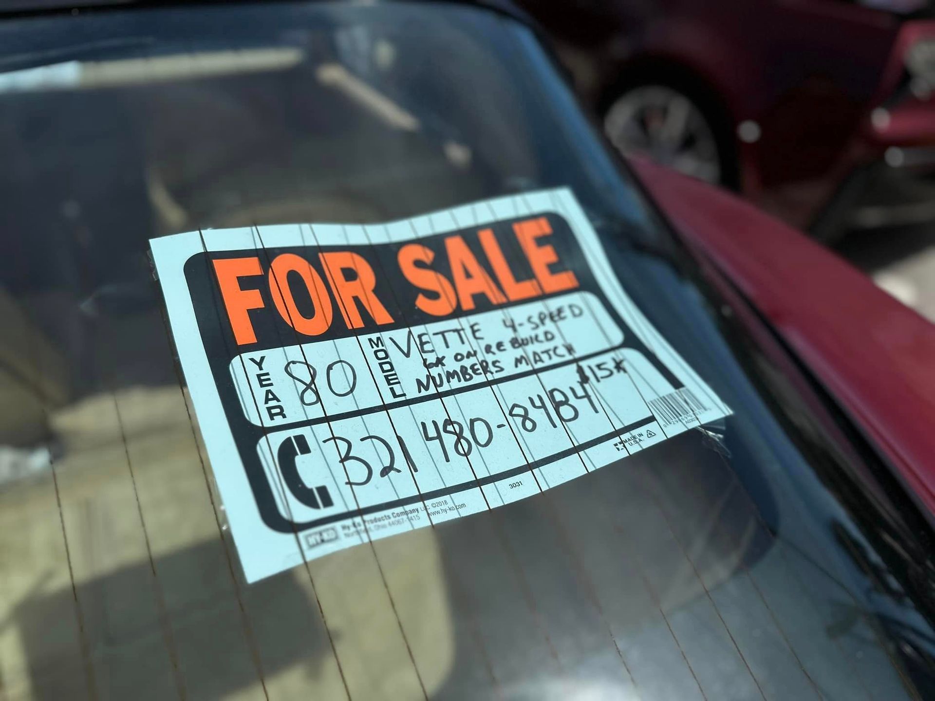 A car with a for sale sign on the windshield