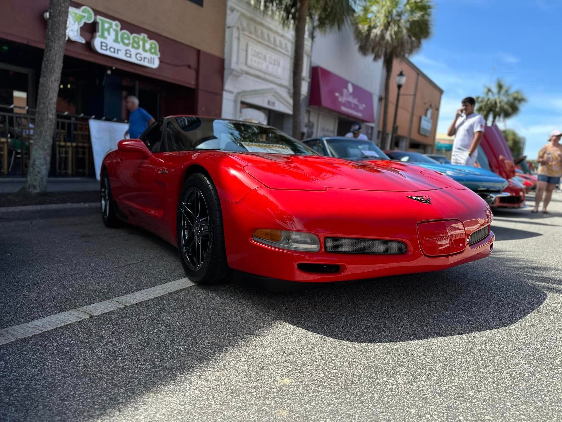 A red sports car is parked in front of fiesta bar & grill