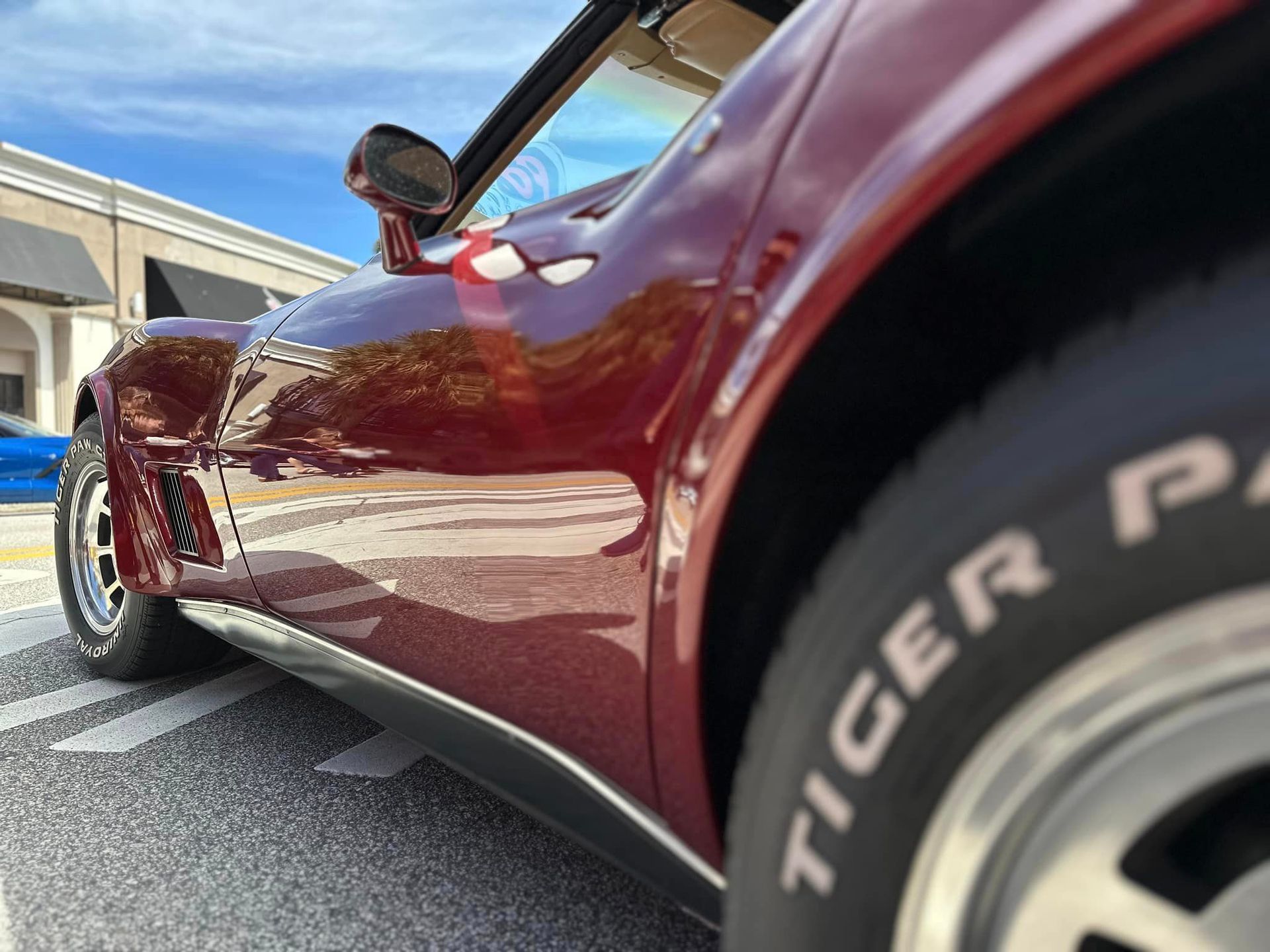 A red car with a tire that says tiger on it