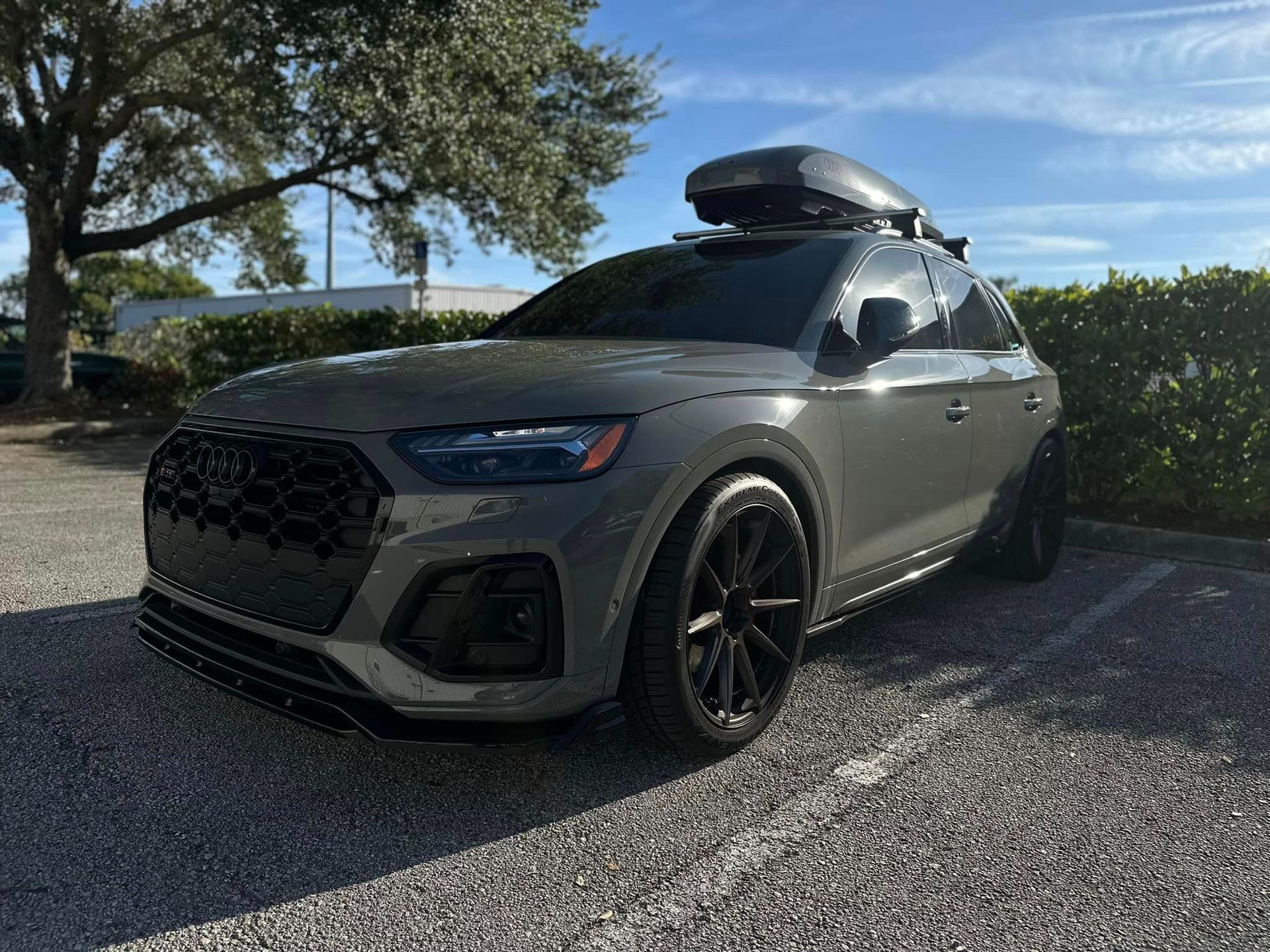 A car with a roof rack on top of it is parked in a parking lot.