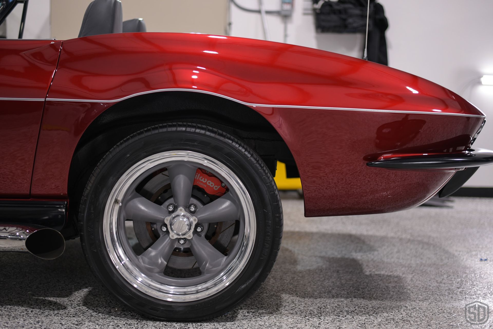 A red sports car is parked in a garage.