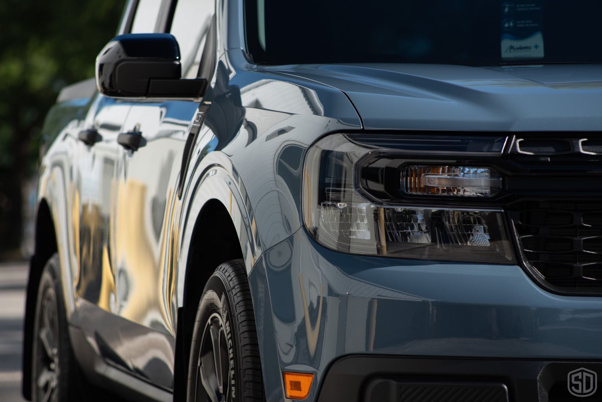 A blue pickup truck is parked on the side of the road.