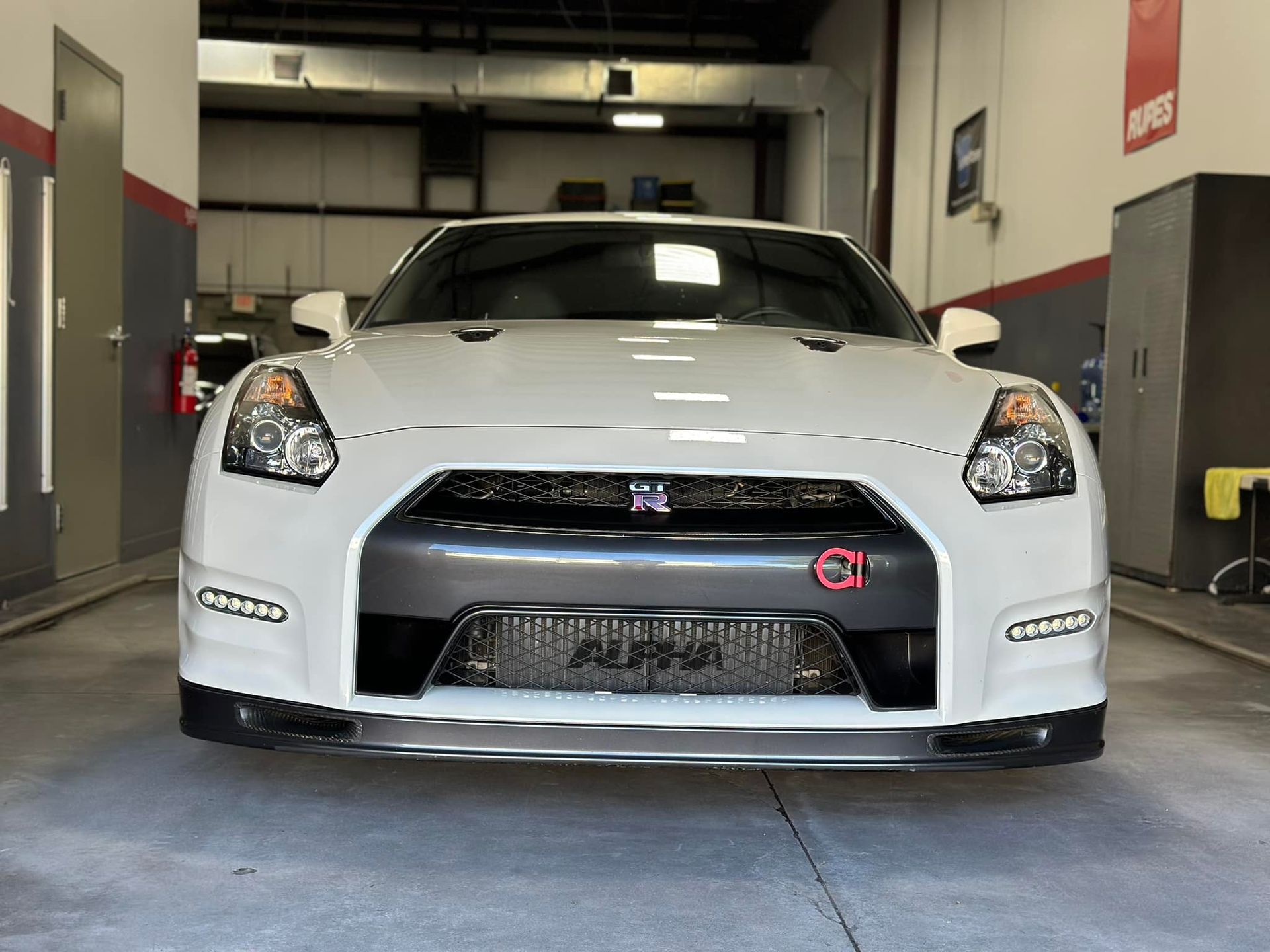 A white sports car is parked in a garage.