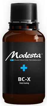 A brown bottle with a black label and a blue cross on it.