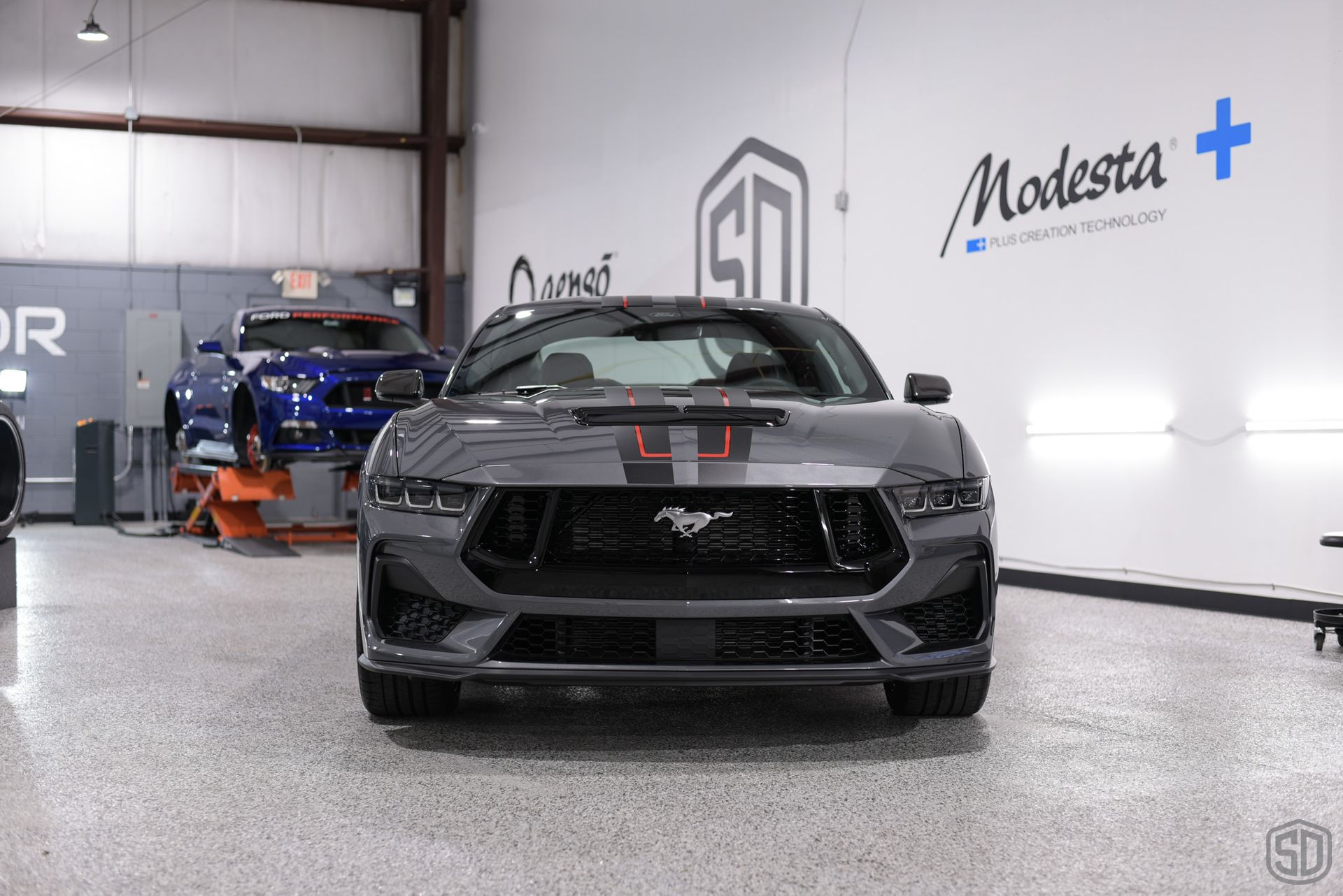 A gray ford mustang is parked in a garage.