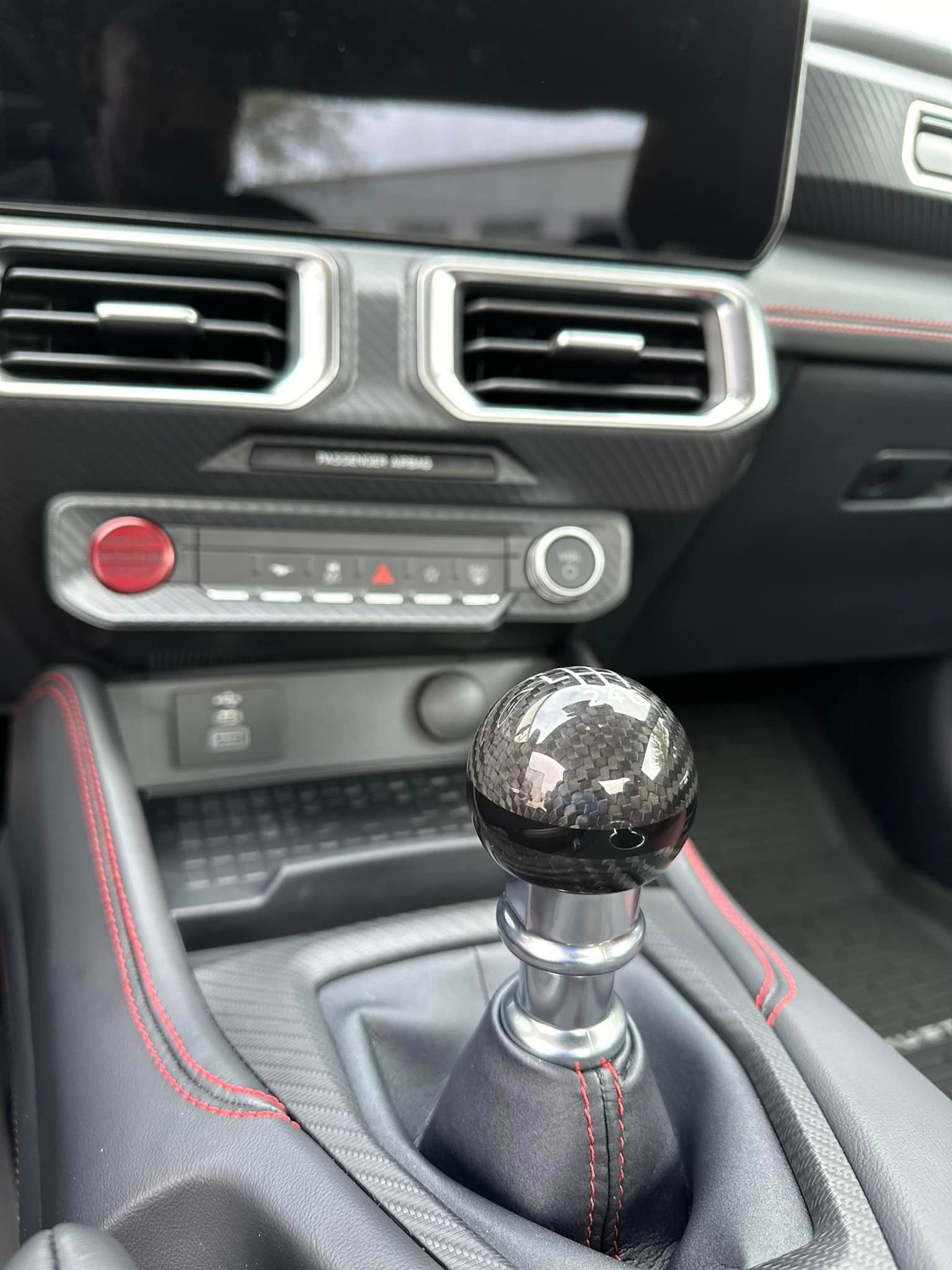 A close up of a shift knob in a car.
