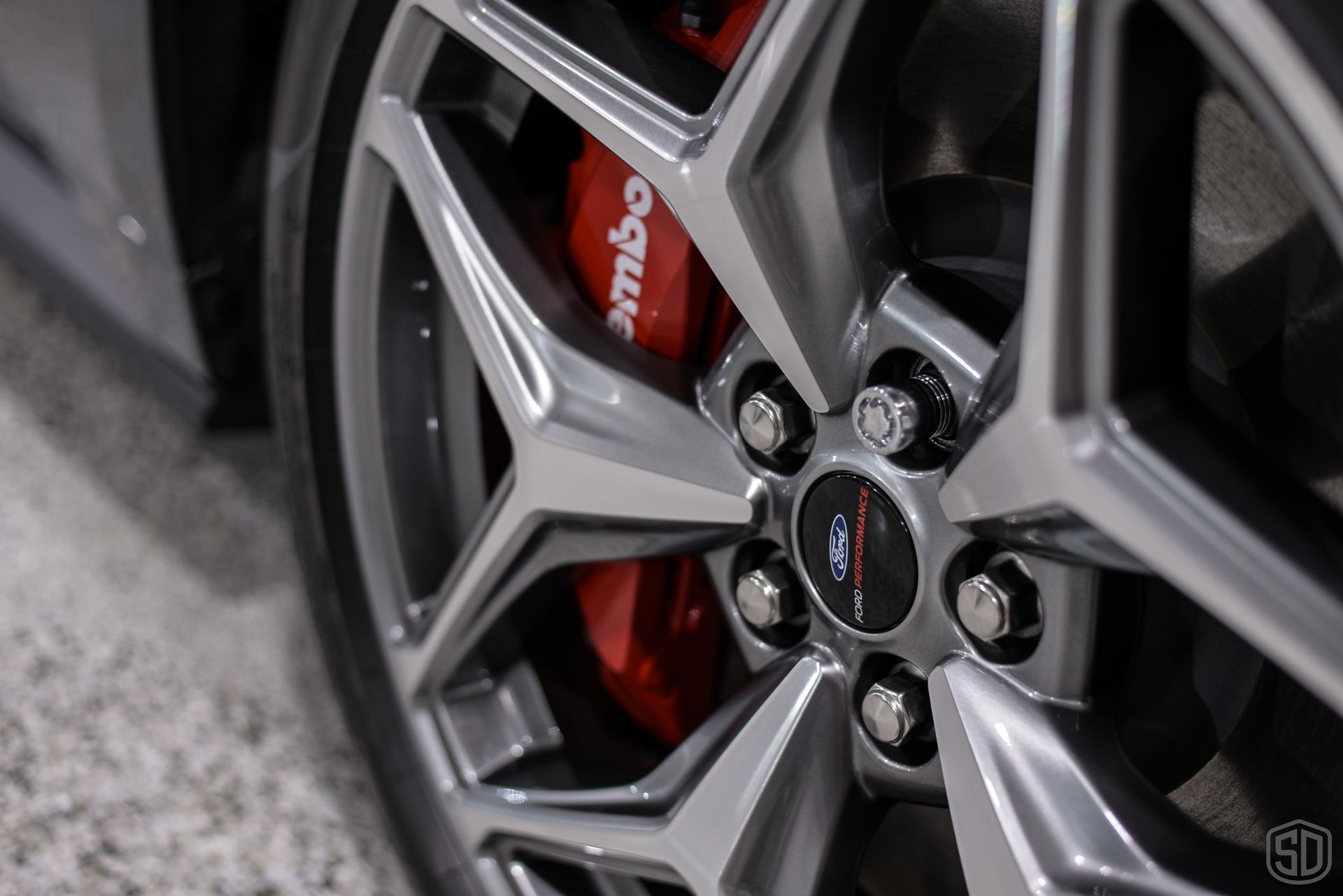 A close up of a brembo brake caliper on a car wheel