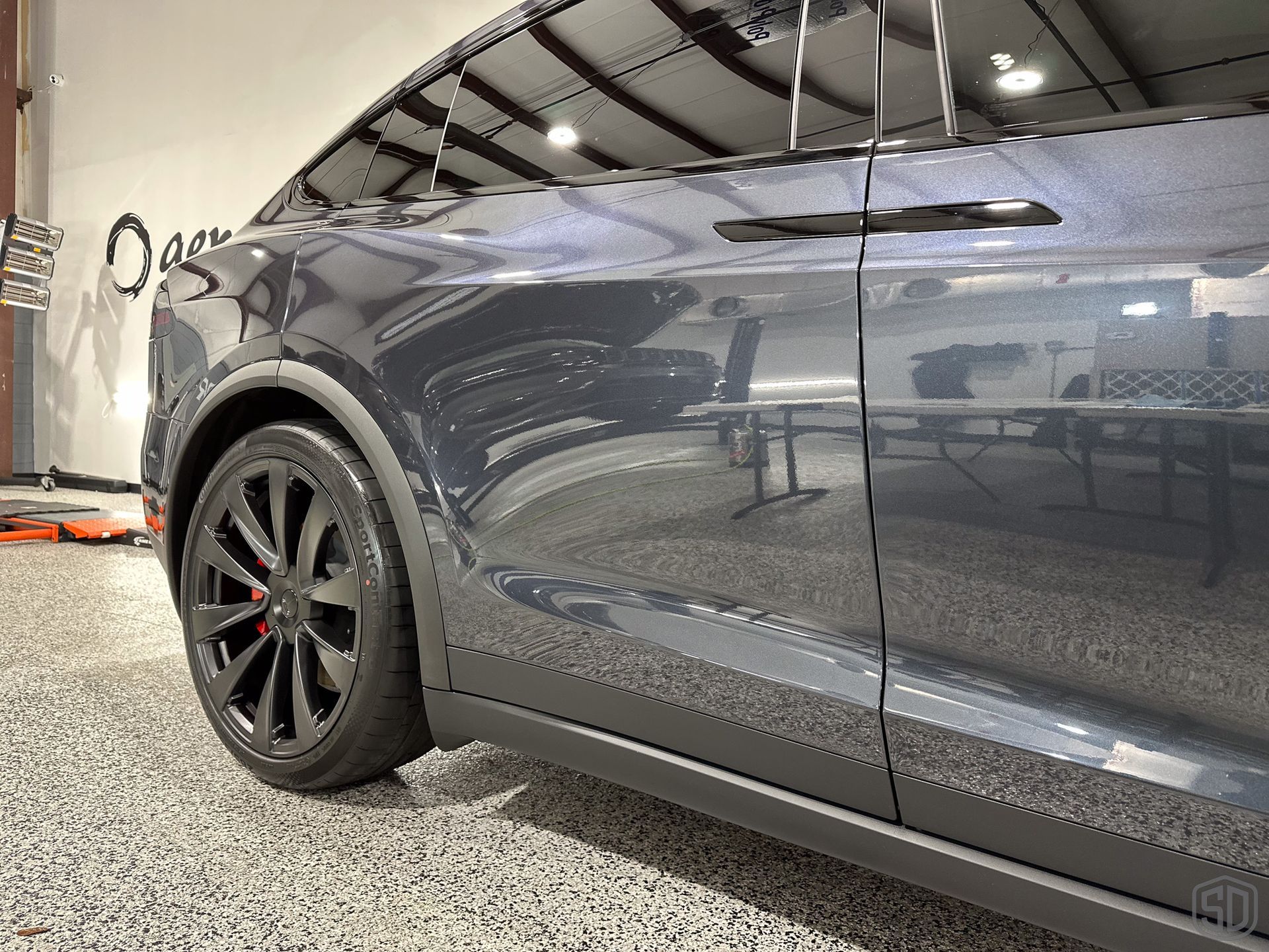 A tesla model x is parked in a garage.