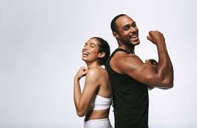 Smiling man and woman flexing muscles, back-to-back against a white background.