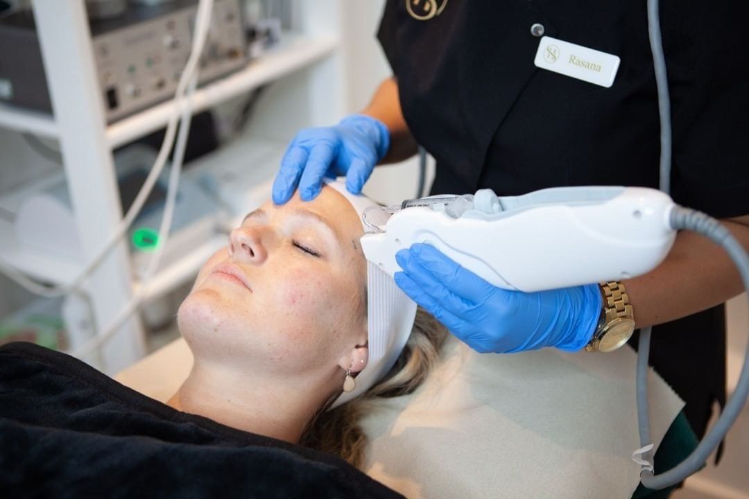 A woman is getting a facial treatment at a beauty salon.