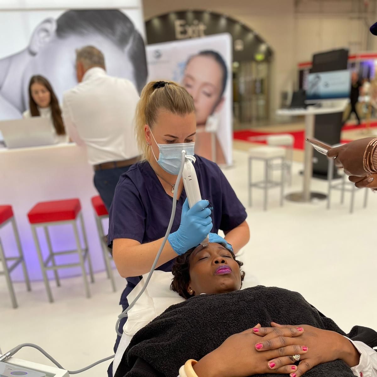A woman wearing a mask is getting a facial treatment