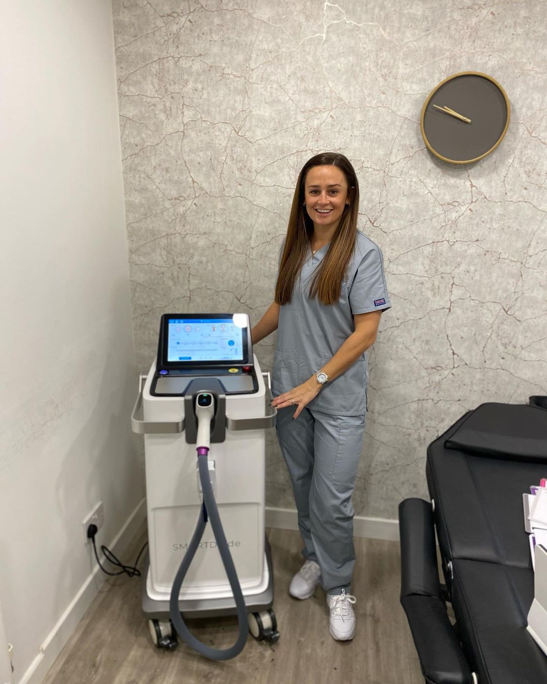 A woman is standing next to a machine in a room.