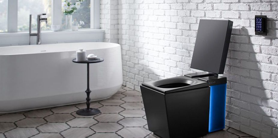 Modern black toilet with open lid in a bright, white bathroom. Blue accent on the side, control panel on the wall.