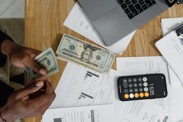 person counting money with calculator