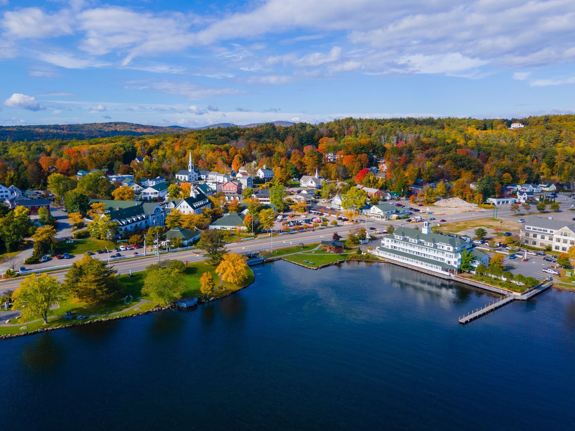An aerial view of a small town surrounded by trees and a lake.