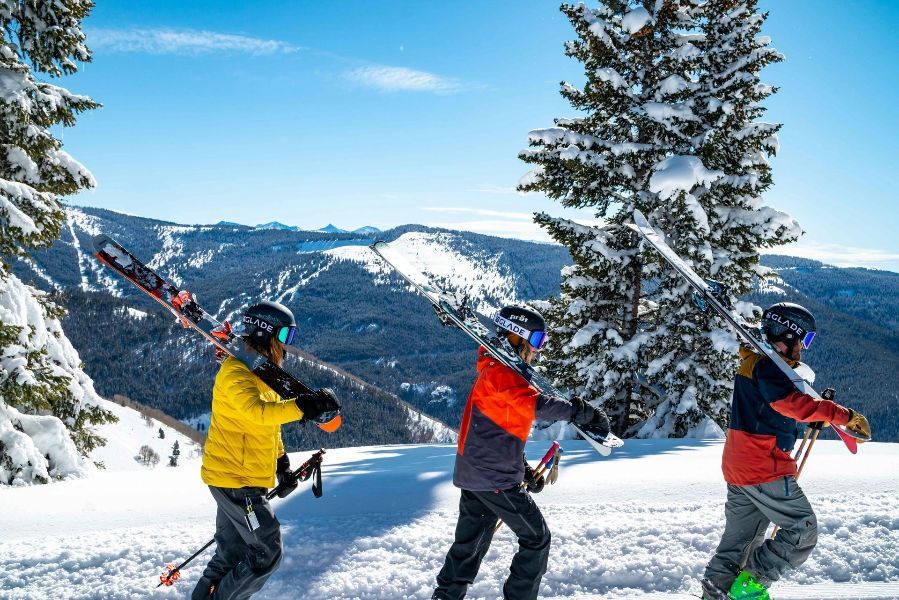 A group of people are skiing down a snow covered slope.