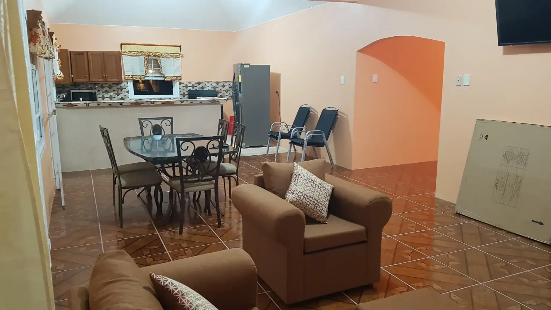 A living room with a couch , chair , table and chairs.