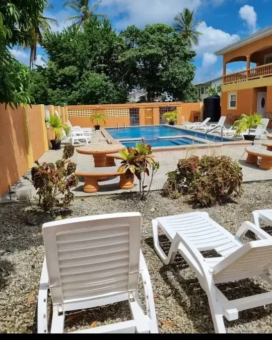 a swimming pool with chairs and tables in front of it