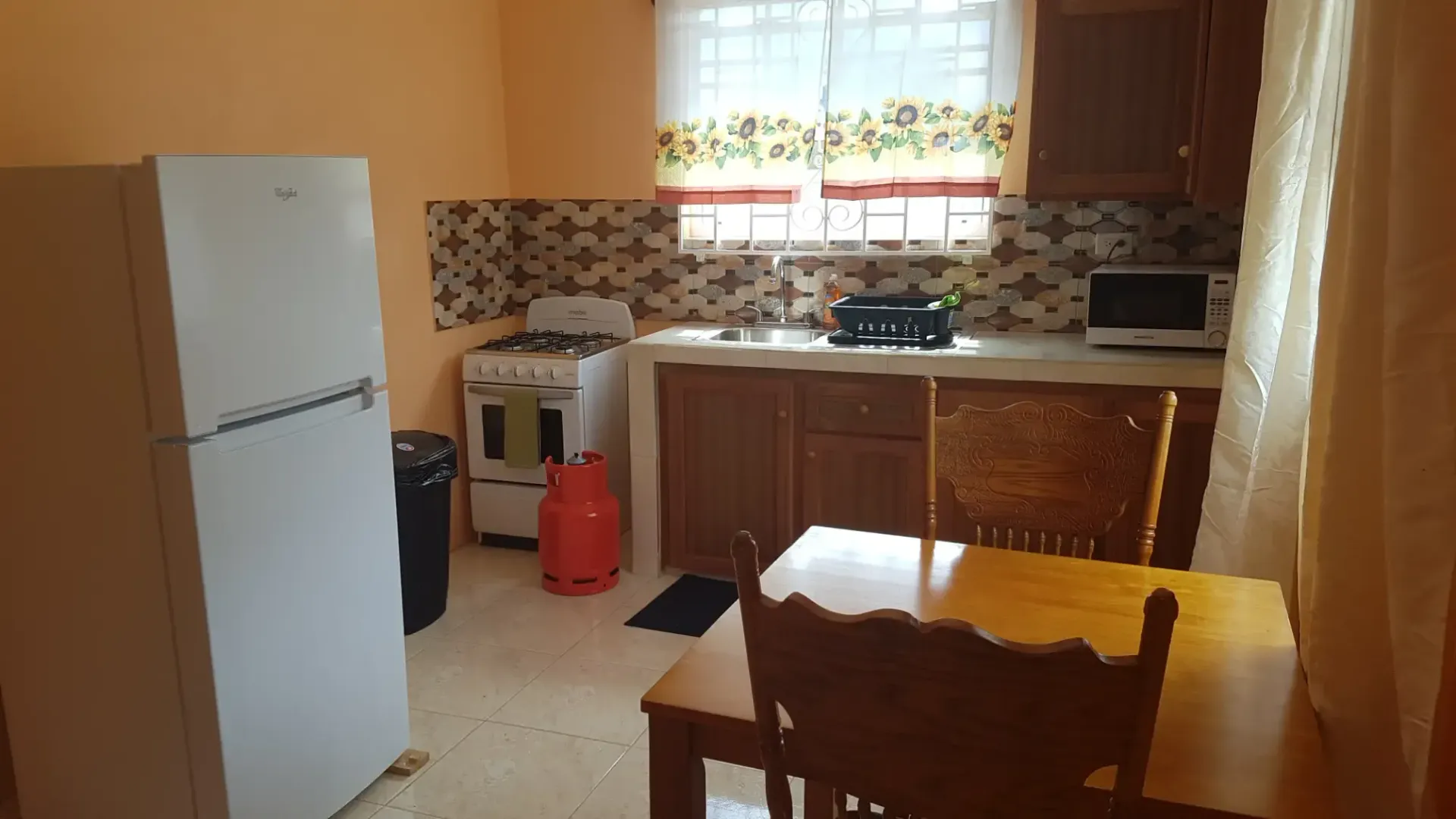 A kitchen with a table and chairs and a refrigerator