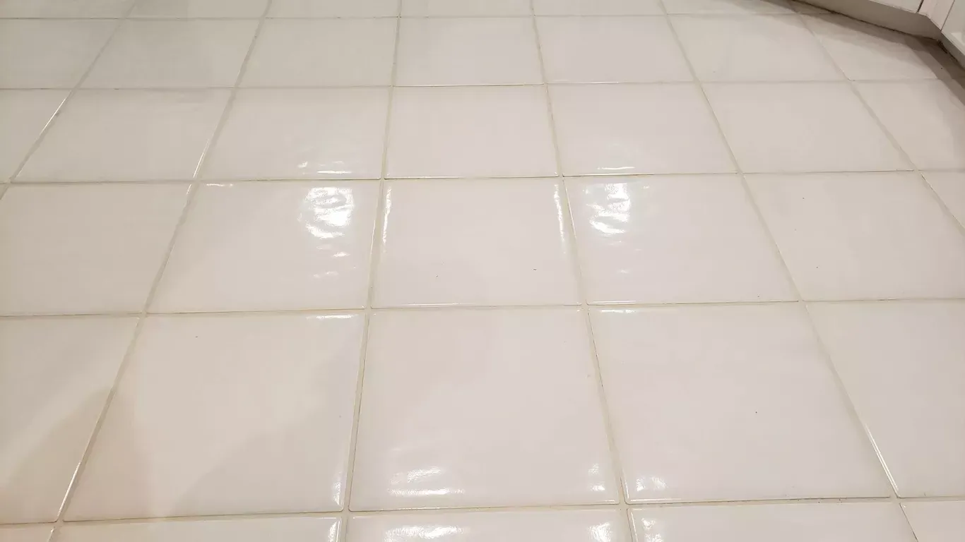 White tiled floor with a few wet, reflective spots.