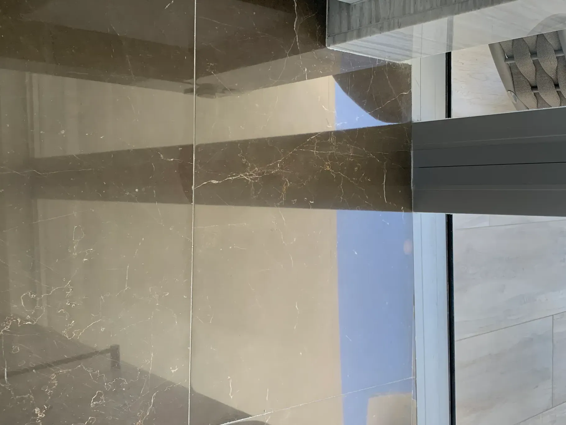 Frosted glass door with horizontal dark stripes and a view of sky and building outside