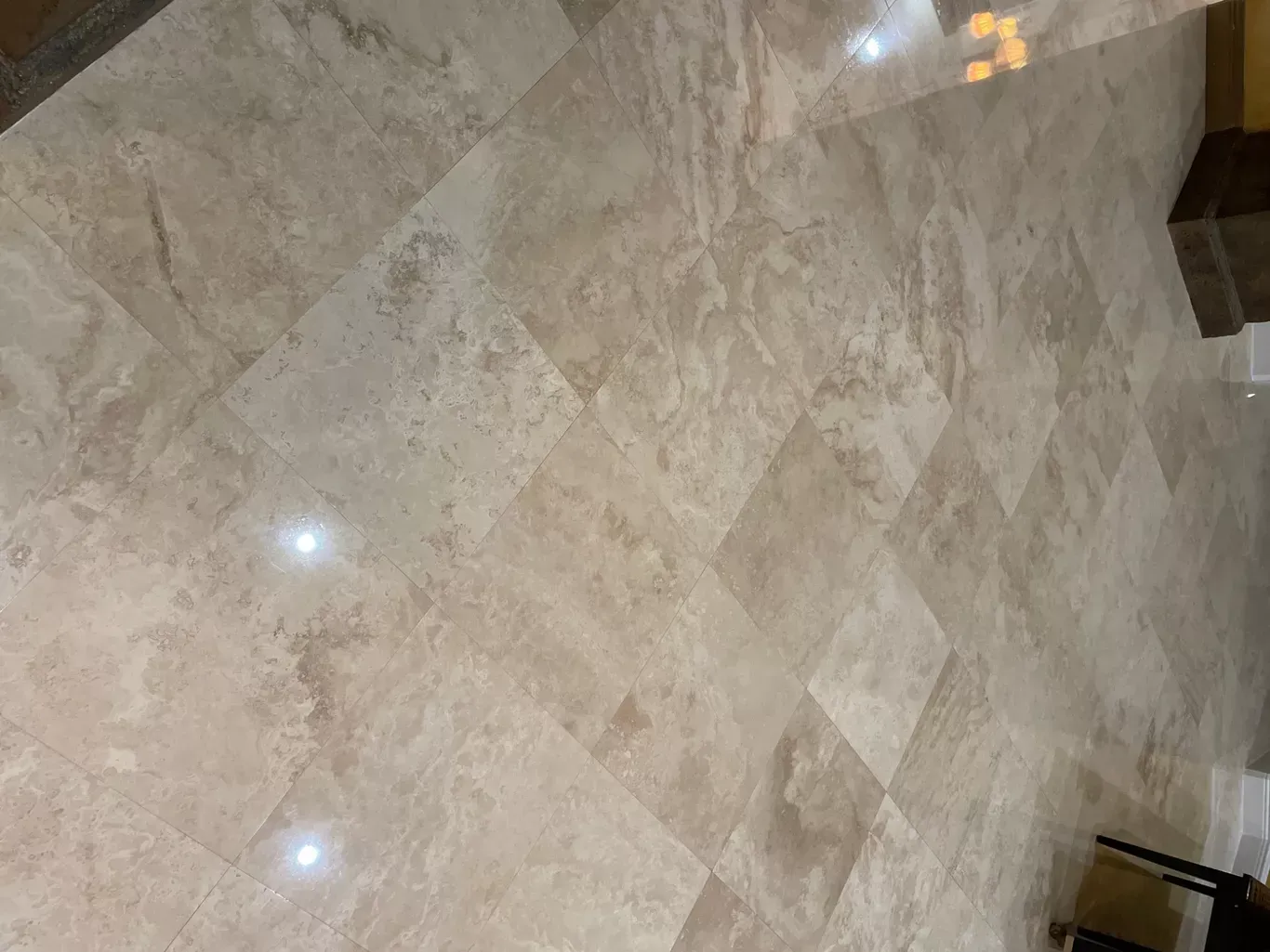 Beige marble tile floor with glossy reflections