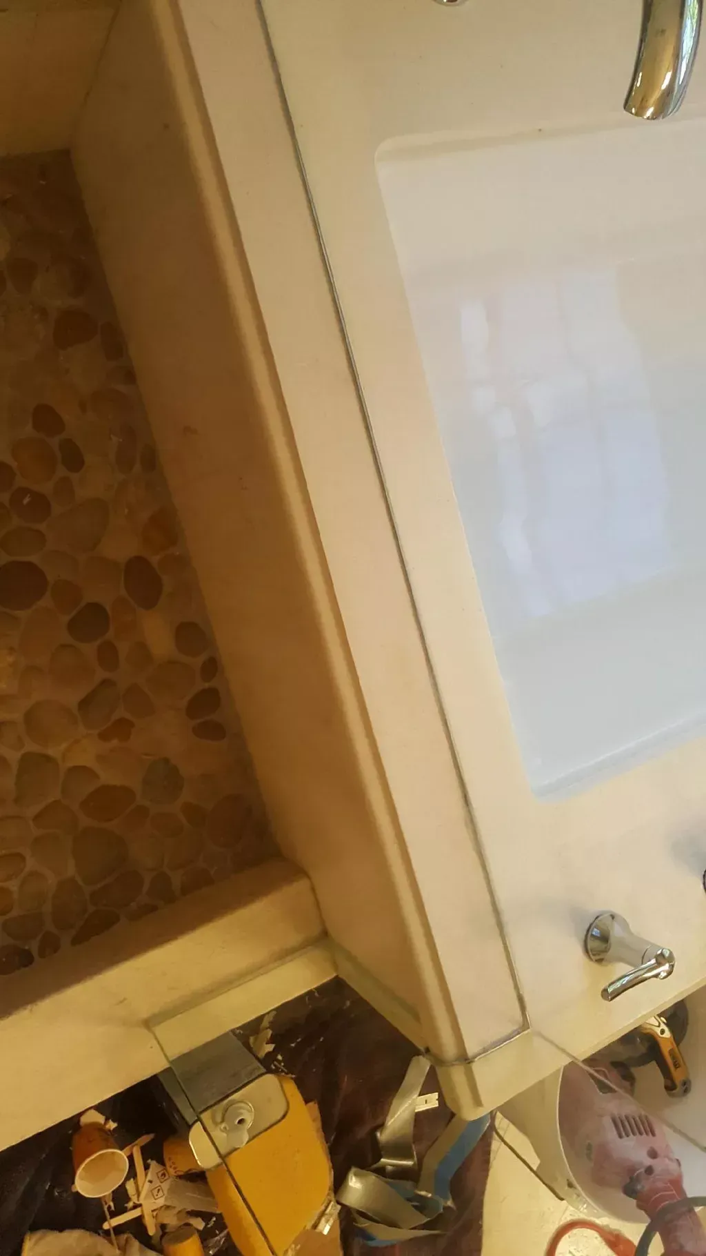 Partially open bathroom cabinet with white door, tiled floor, and sink faucet visible above.