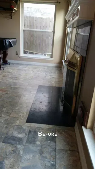 Living room with stone tile floor, black hearth mat, fireplace, and large window labeled “Before”