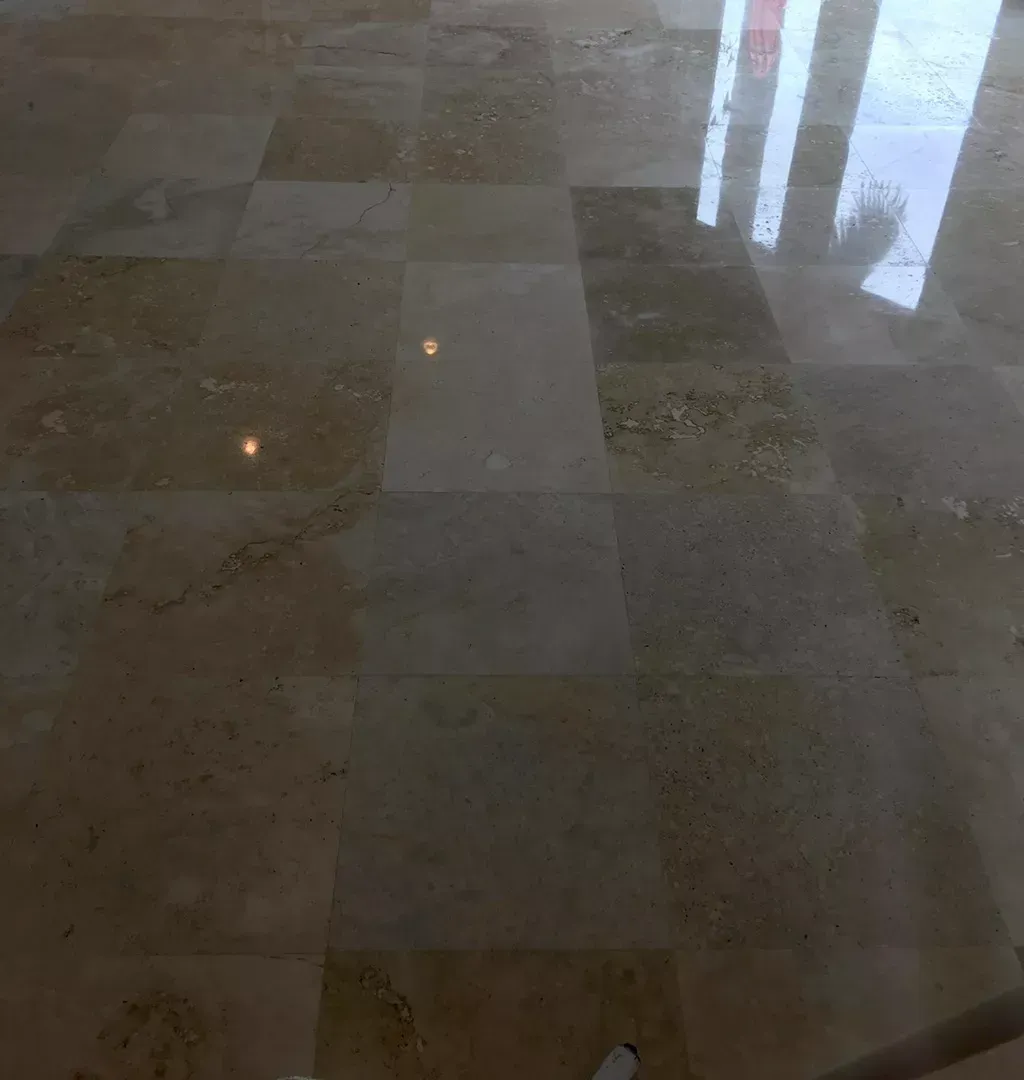 Polished marble floor with window reflections and faint light spots