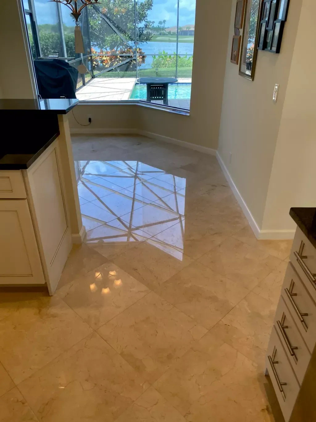 Bright kitchen floor reflecting a window view of a lake and patio outside