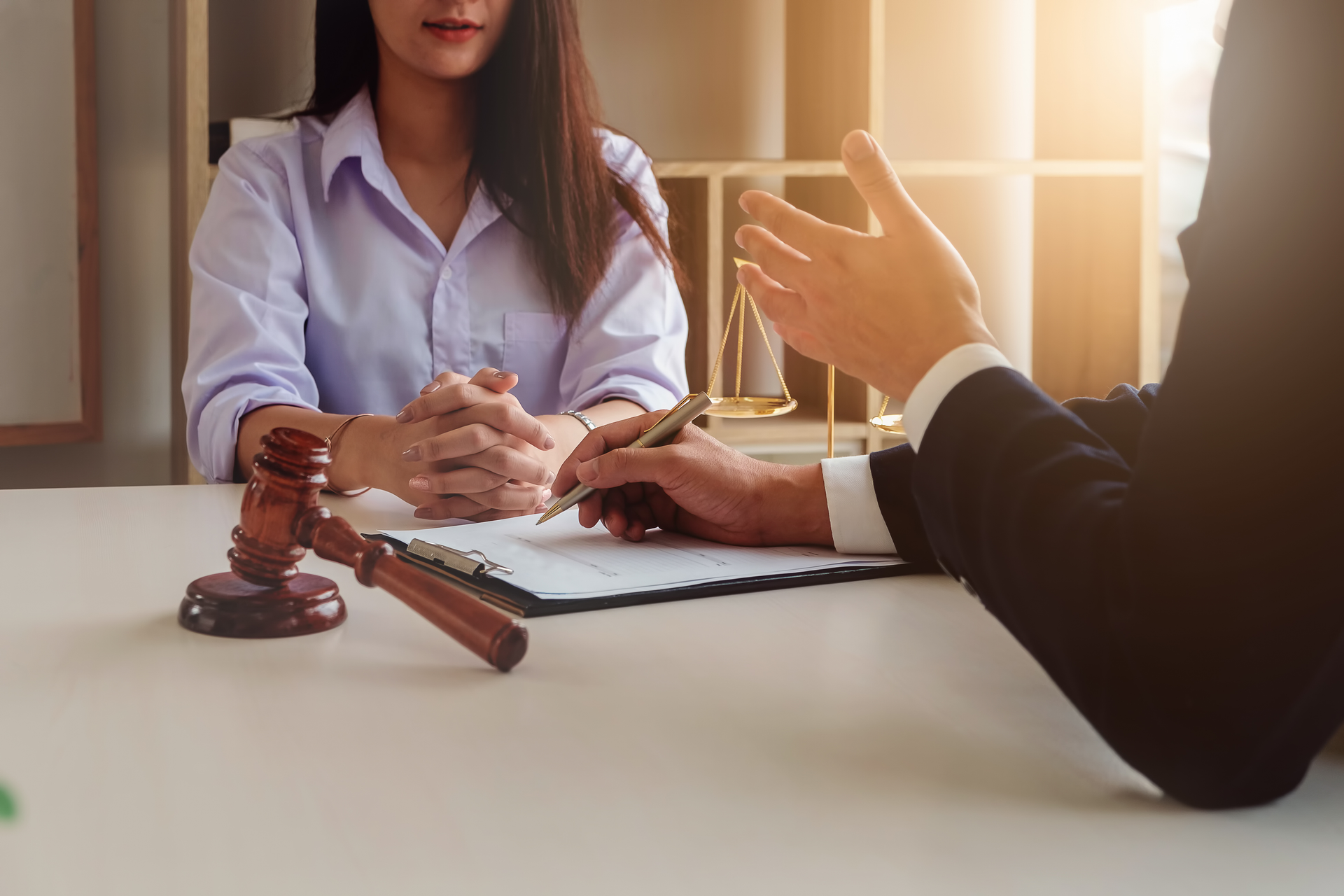 A man and a woman are sitting at a table with a judge 's gavel.