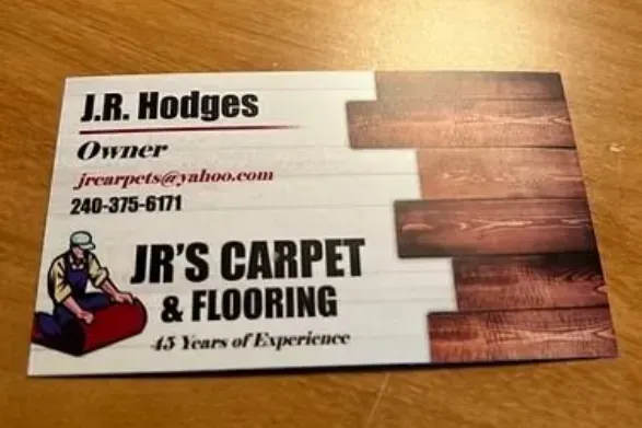 Business card for JR's Carpet & Flooring, with contact info and a graphic of a flooring installer.