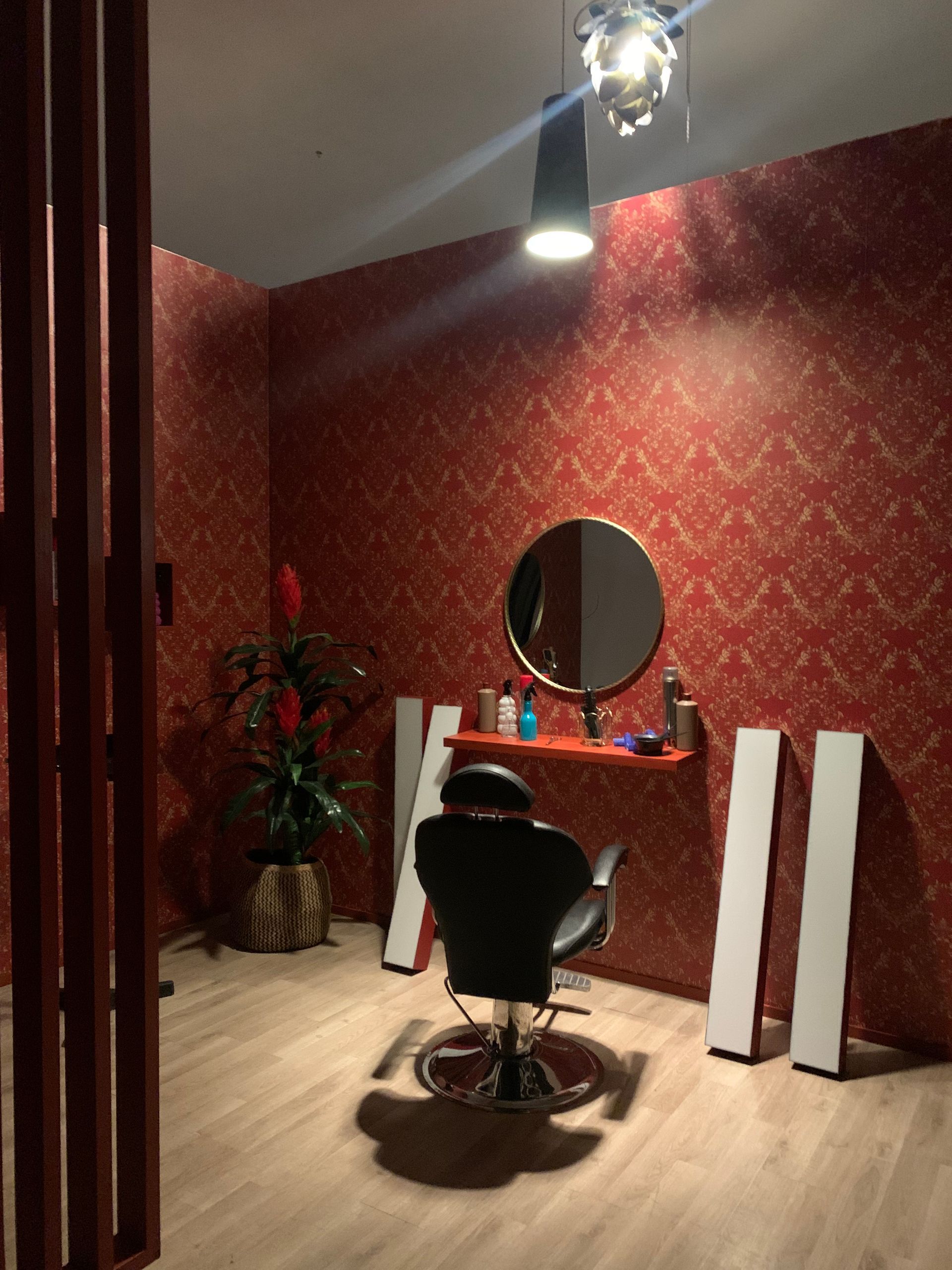 Due persone in uno studio fotografico, una che guarda il monitor della telecamera e l'altra seduta lì vicino con le braccia incrociate.