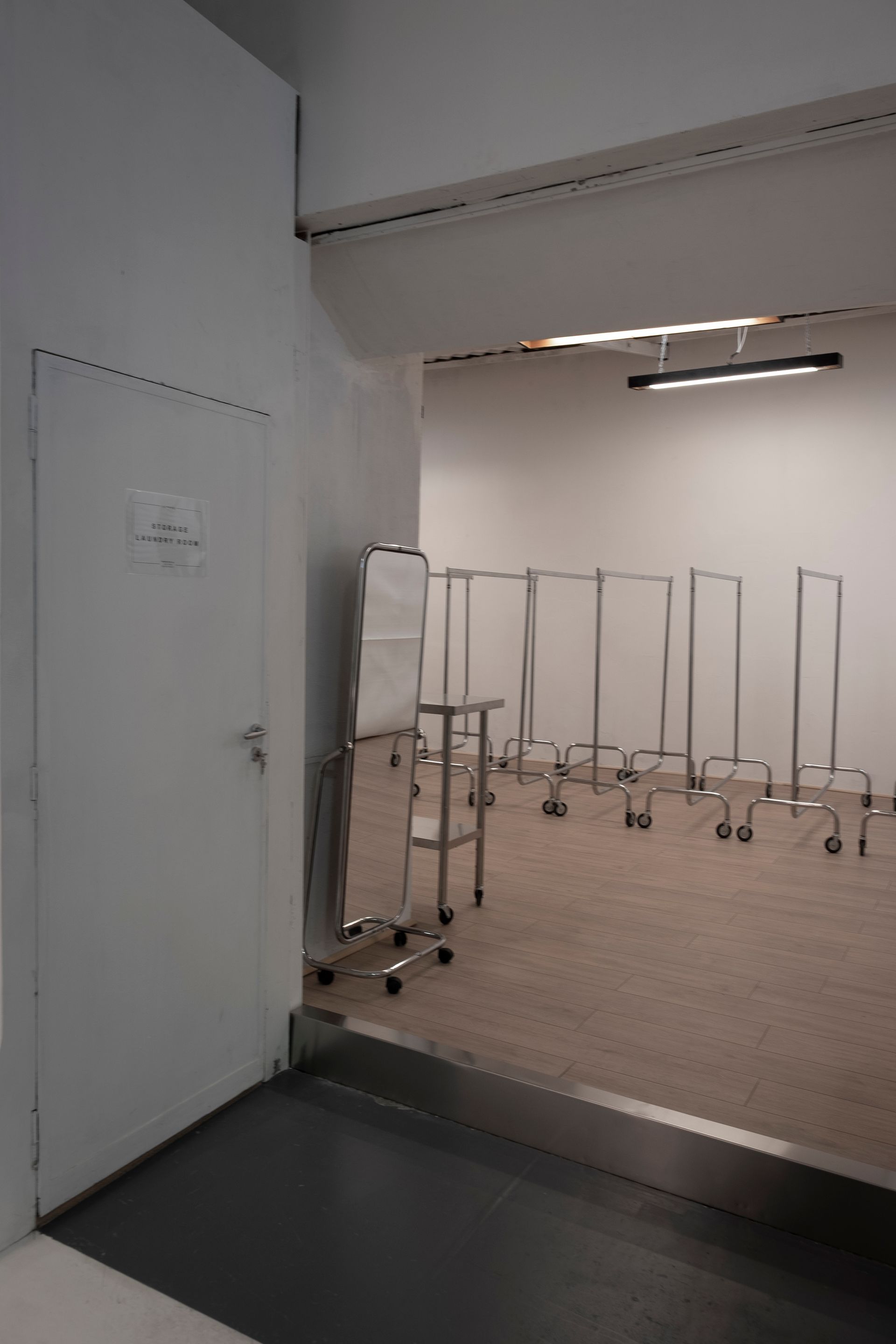Uno studio fotografico professionale con sfondo bianco, illuminazione softbox e diffusore di luce su un pavimento di cemento grigio.
