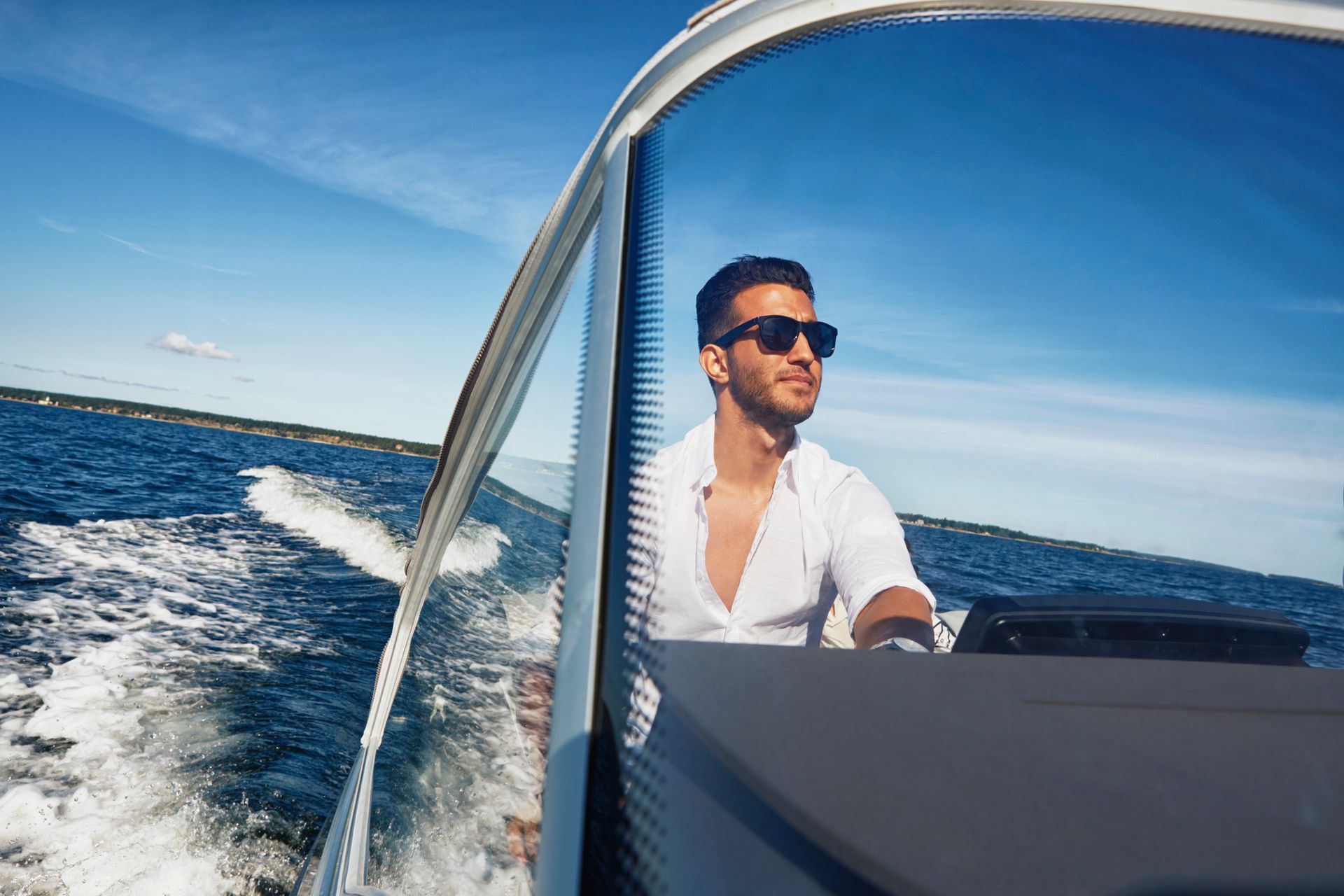 Young man steering boat using top-quality accessories for smooth, secure docking.