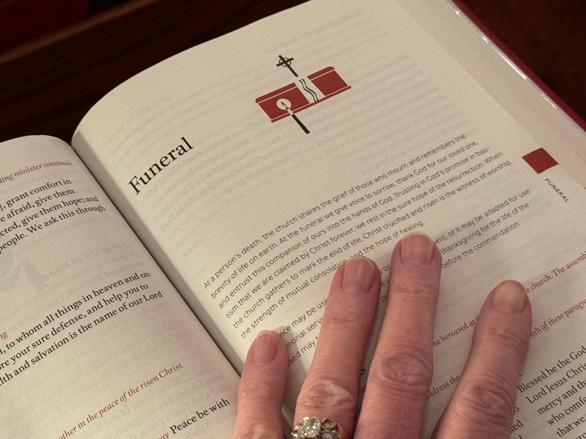 A hand holds open a book with the word