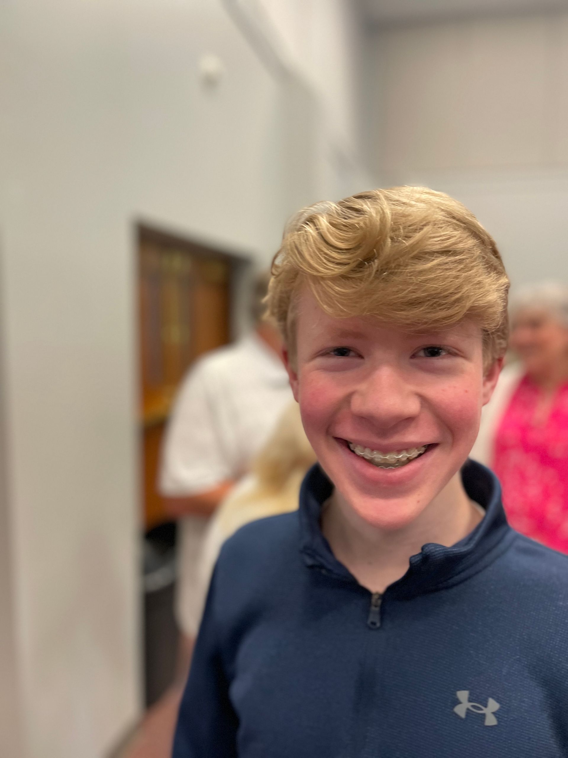 A child smiles in front a blurred background