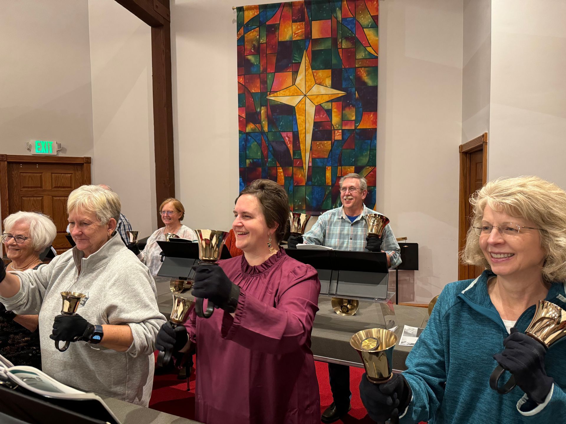 People smile in a church holding handbells